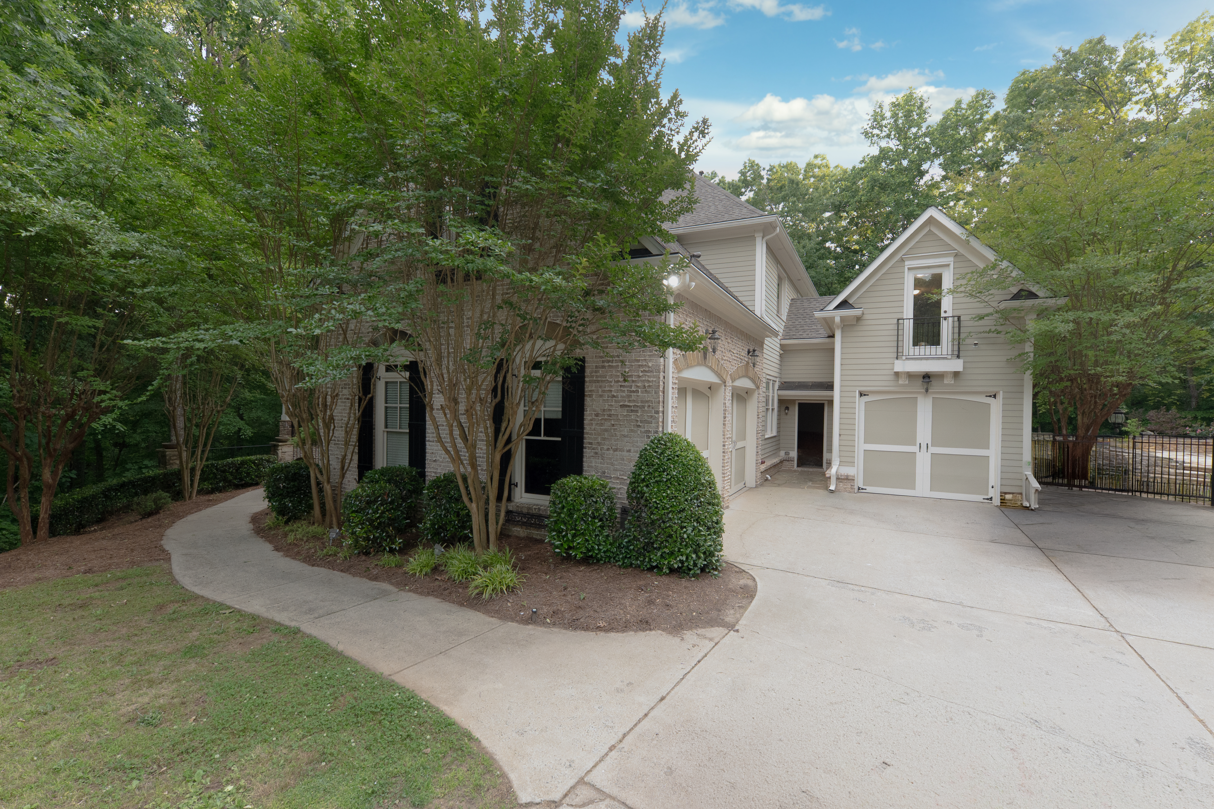 Street arrival — circular drive, crape myrtles, facade and garage wing