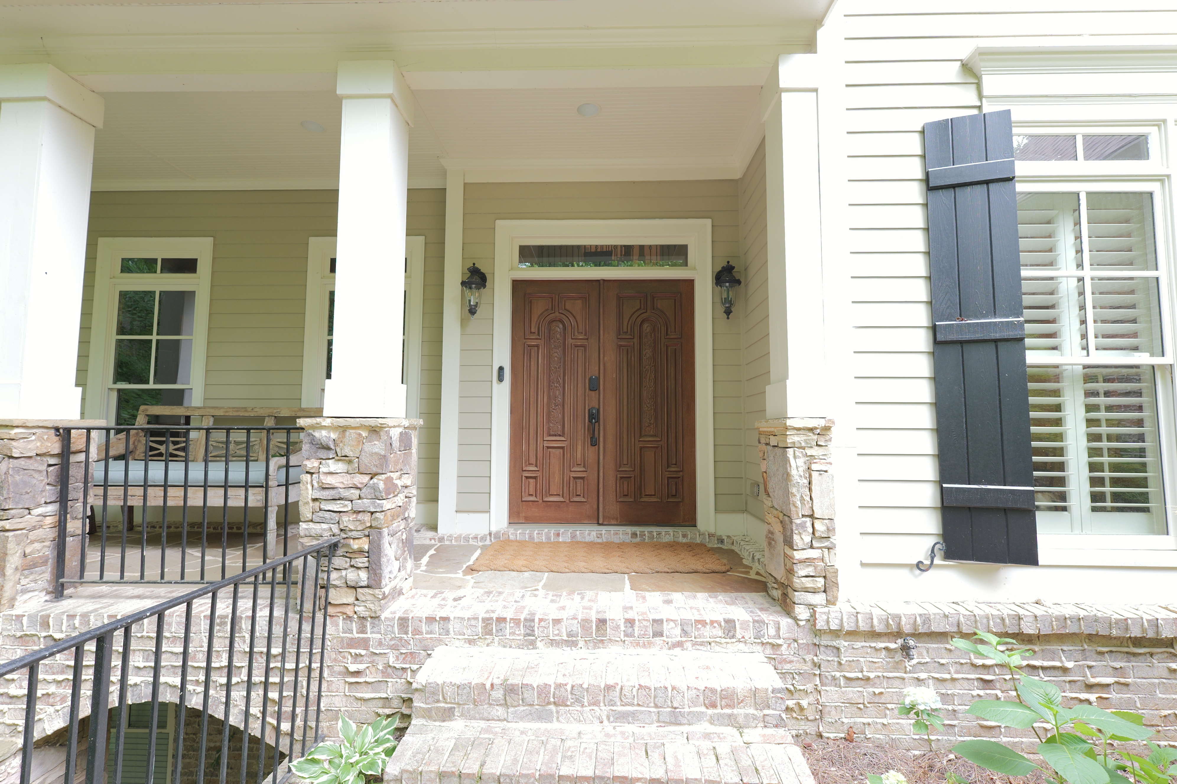 Front door — carved walnut double doors with lanterns
