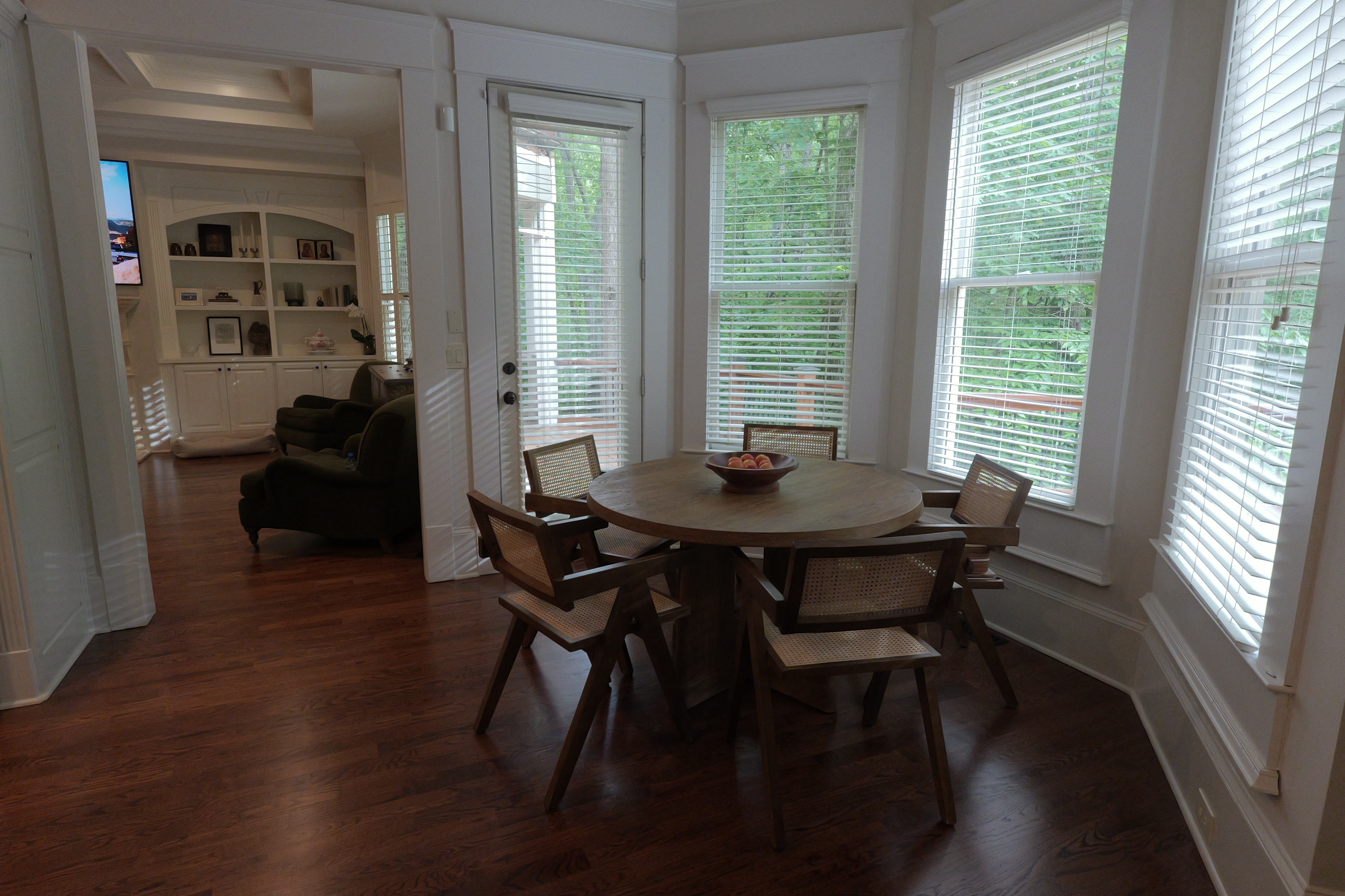 Breakfast nook — round table, cane chairs, garden windows