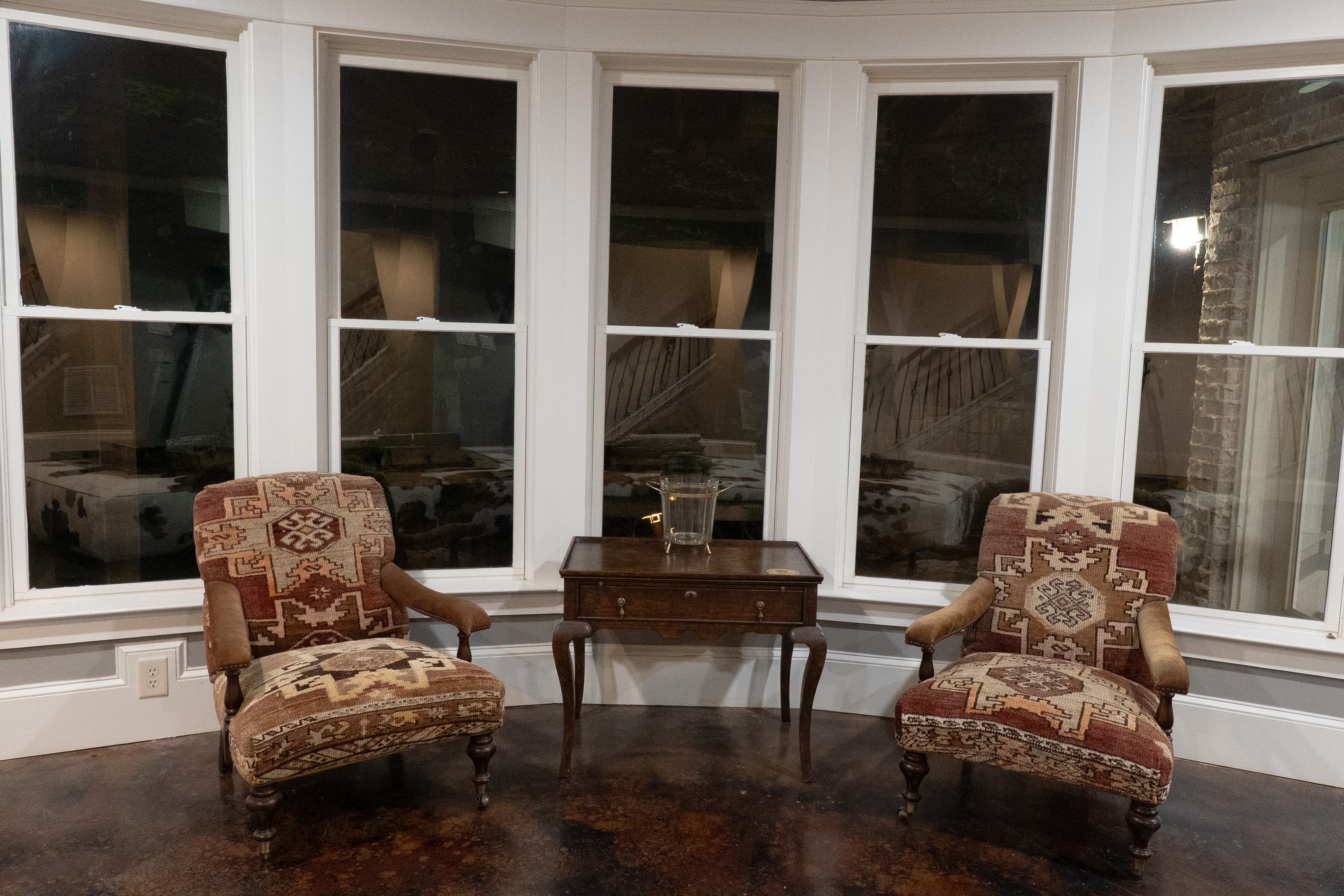 Kilim chairs in curved bay window — moody and intimate